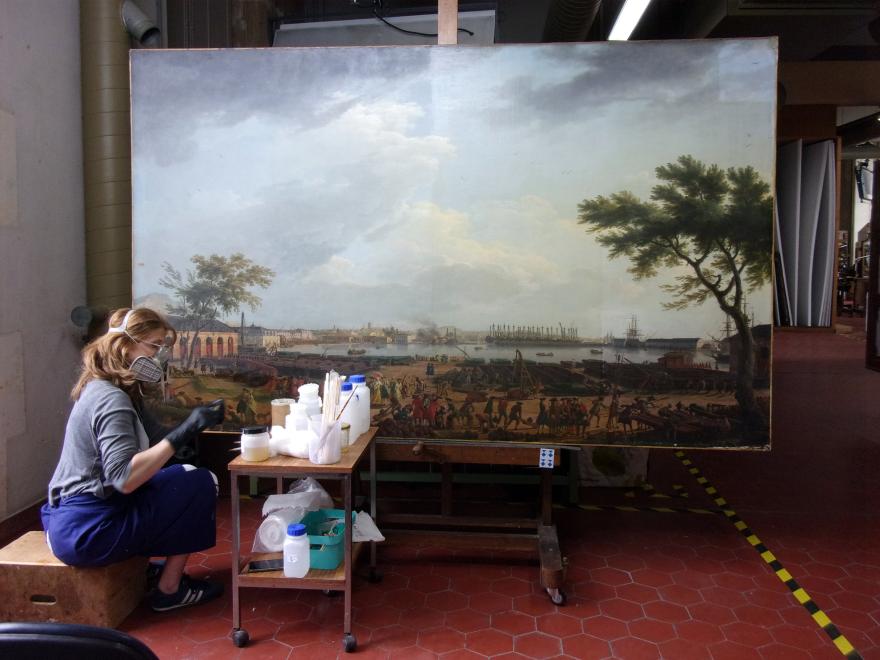 Fig 3 :  La restauratrice Alix Lavau dans l’atelier de restauration de peintures du site de Versailles pendant la restauration des 13 vues des Ports de France de Vernet