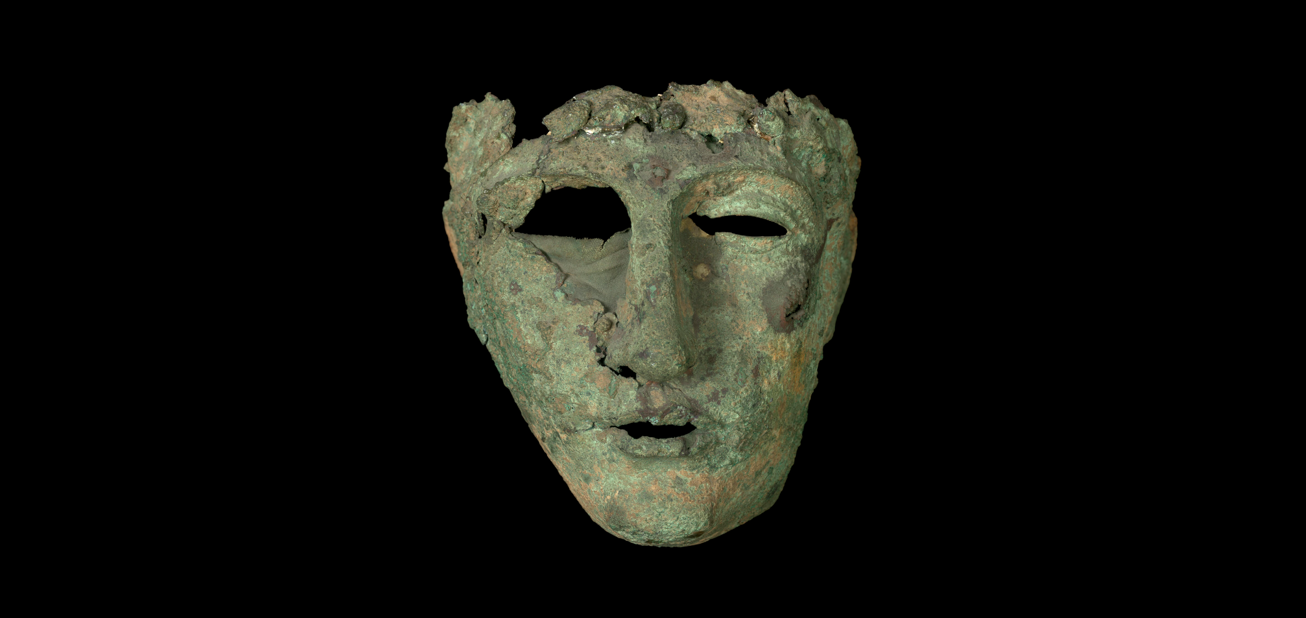 vision complète de l'oeuvre sur fond noir, le masque est altéré, avec entre autre un trou plus important sur l'oeil droit que le gauche.